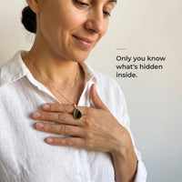 Thumbnail for Woman holding the black teardrop pendant on its gold chain against her chest, only she knows the photo inside | SKU: TPH-DRPN-GOLD