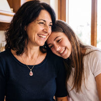 Thumbnail for Mother and teenage daughter hugging and laughing, the mother wearing the gold secret drop photo necklace | SKU: TPH-DRPN-GOLD